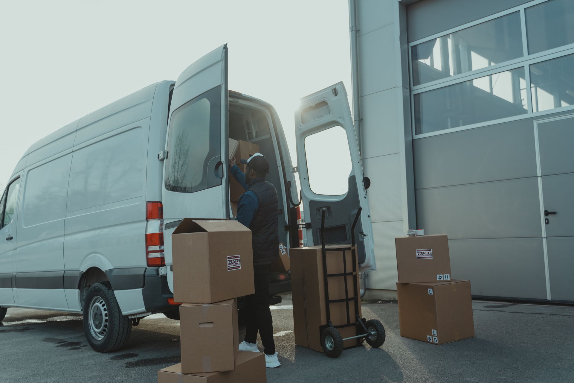 Courier loading parcels into a delivery van