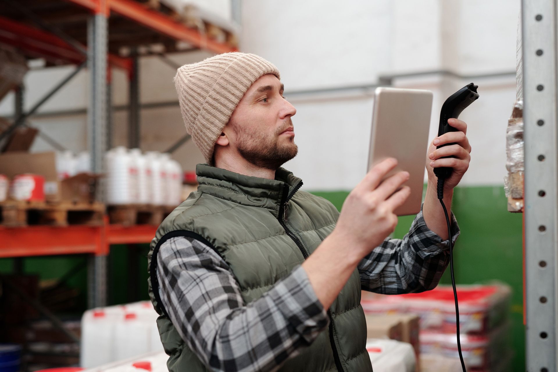 Warehouse worker checking stock with a tablet and handheld scanner