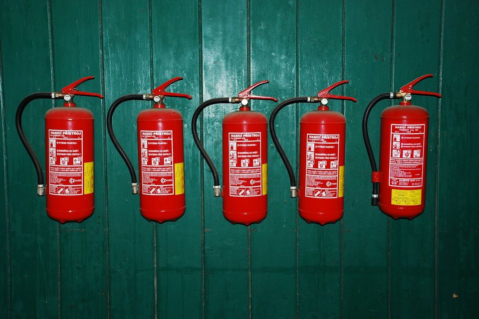 Row of red fire extinguishers on a wall